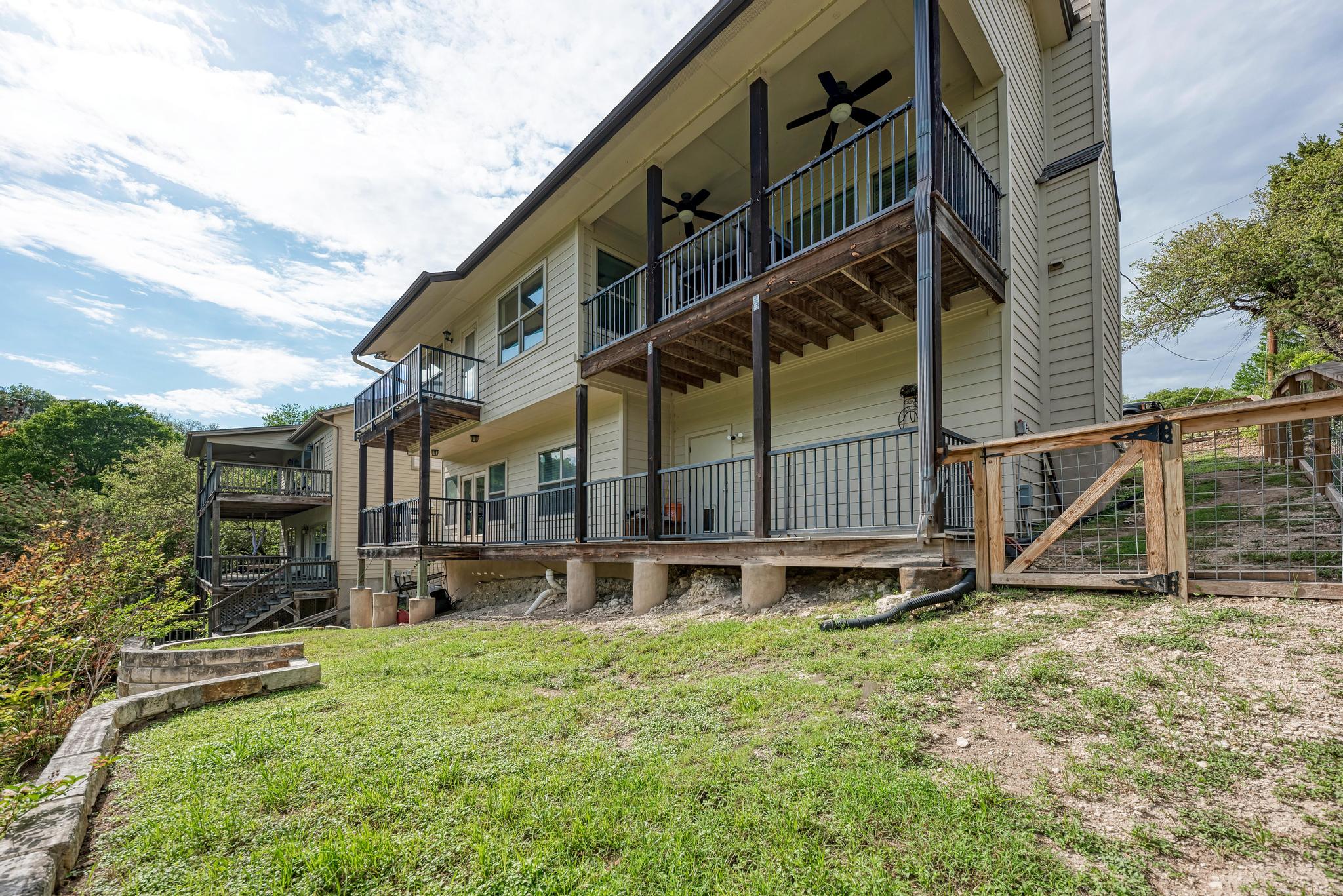 2605 Indian Creek Road Austin, TX 78734 - Photo 31 of 33 Multi-level residence featuring expansive balconies with black metal railings and overhead ceiling fans