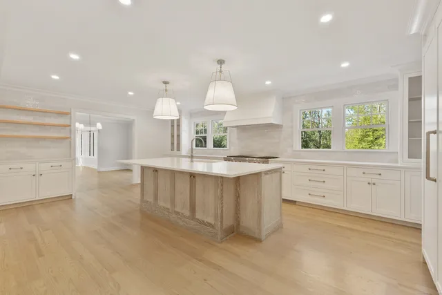 a large kitchen with kitchen island white cabinets and wooden floor