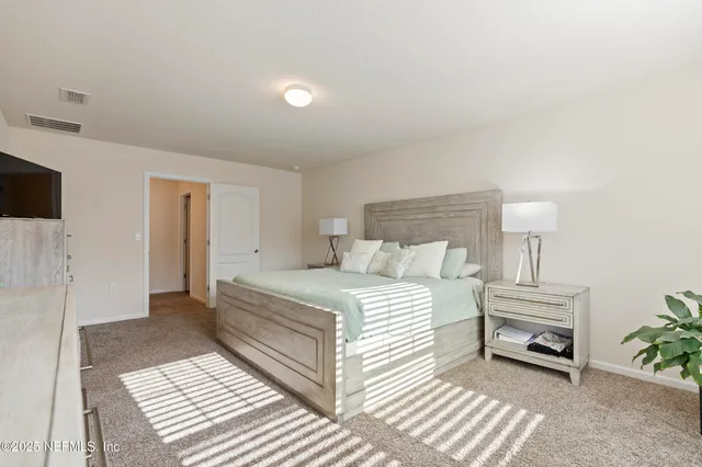 a bedroom with a bed and a lamp on table