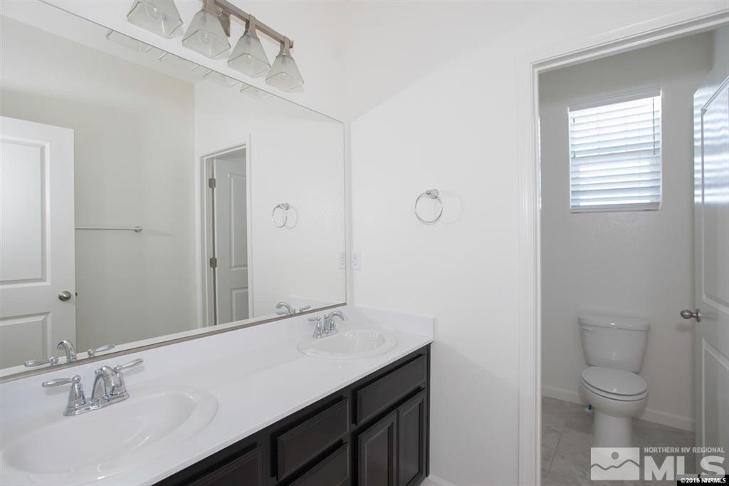 1917 Wind Walker Drive Reno, NV 89521 - Photo 8 of 14 a bathroom with a sink a toilet and a large mirror