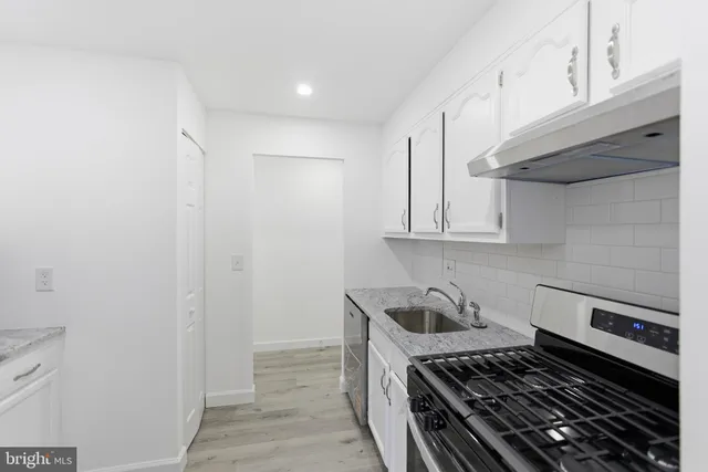 a kitchen with white cabinets and appliances
