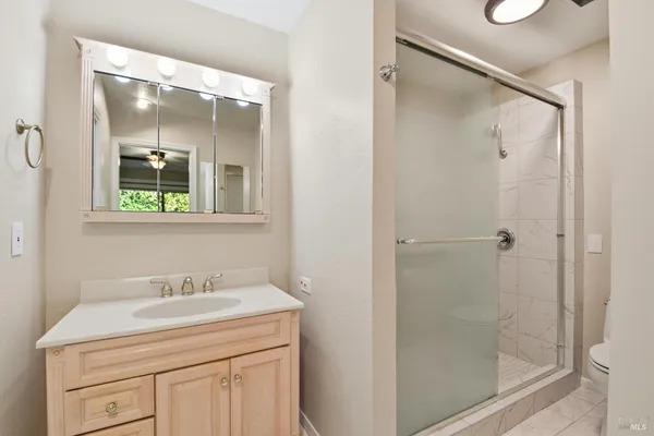 a bathroom with a shower sink vanity and mirror