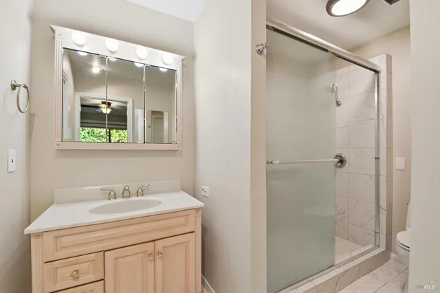 a bathroom with a shower sink vanity and mirror