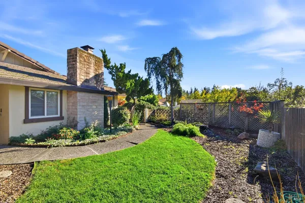 a front view of a house with a yard and outdoor seating