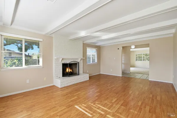 a view of a livingroom with wooden floor and a fireplace