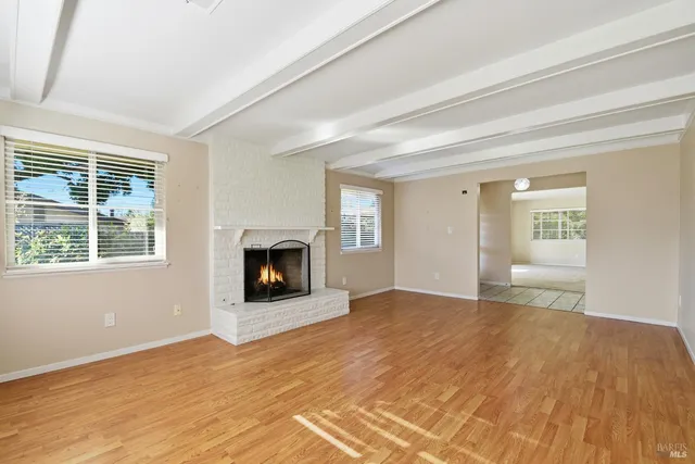 a view of a livingroom with wooden floor and a fireplace