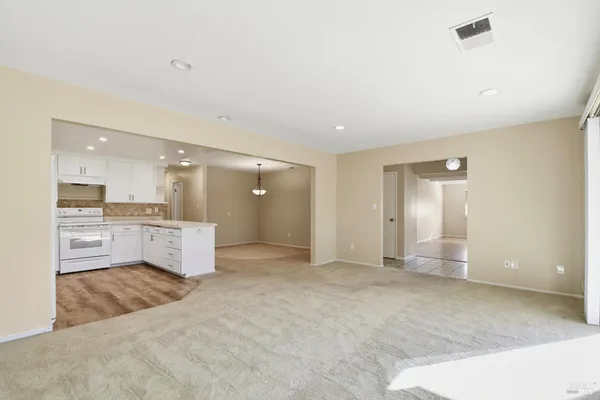 a view of a open kitchen with a sink and cabinets