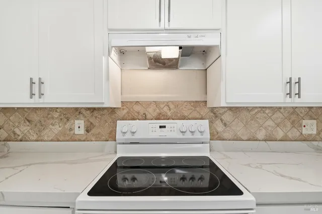 a white stove top oven sitting inside of a kitchen