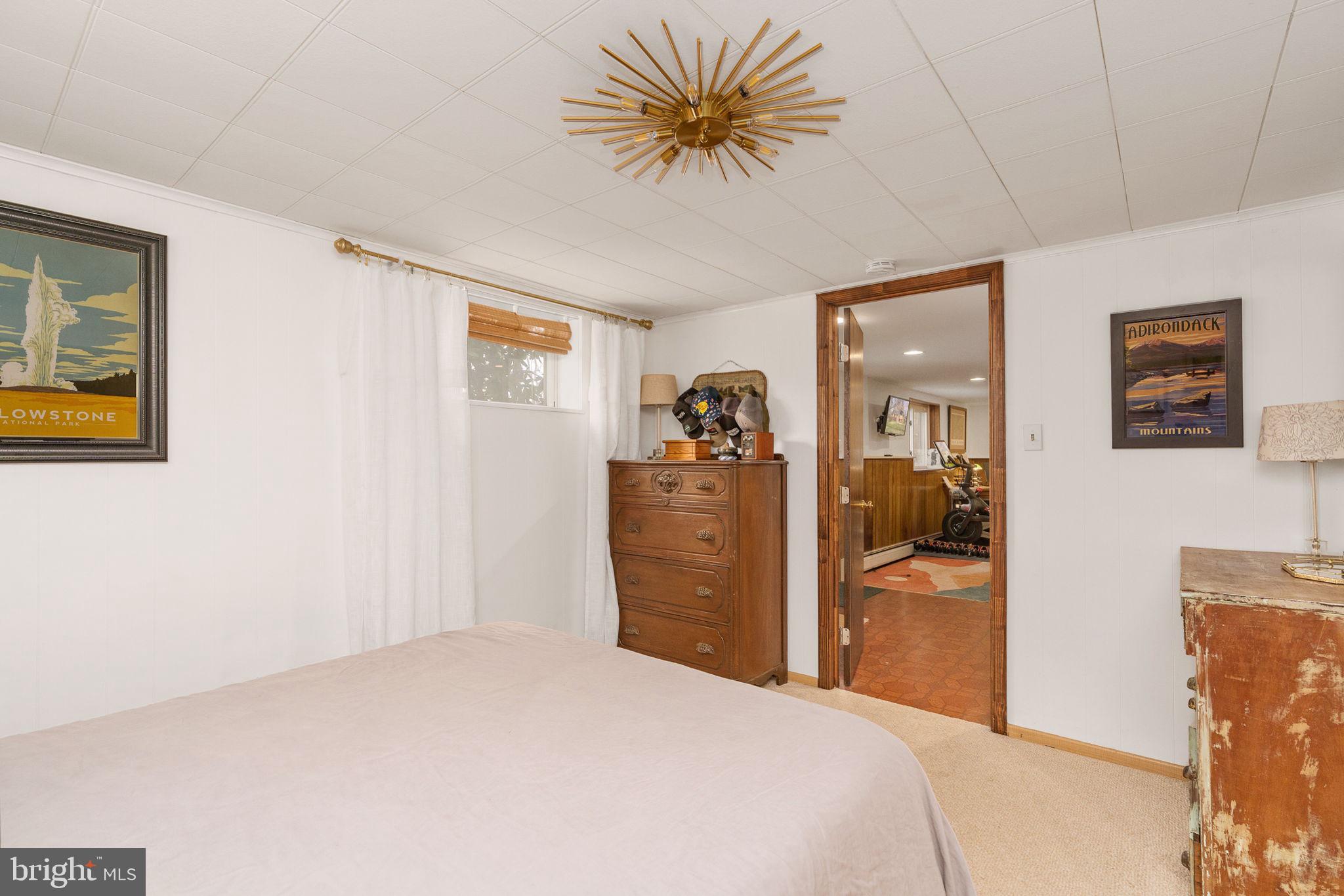 6714 Ruskin Street Springfield, VA 22150 - Photo 44 of 63 a bedroom with a bed and a chandelier
