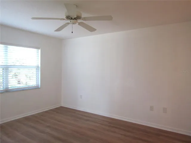 an empty room with a window and a ceiling fan