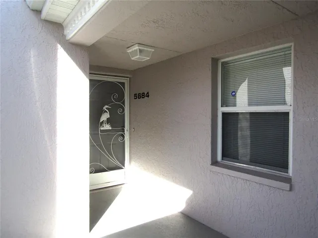a view of a hallway with wooden floor and entryway