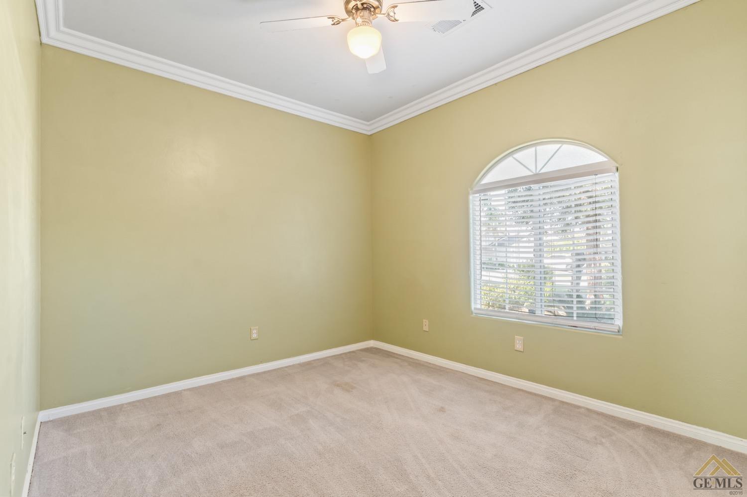 Undisclosed Address Bakersfield, CA 93306 - Photo 22 of 28 an empty room with a chandelier fan and windows