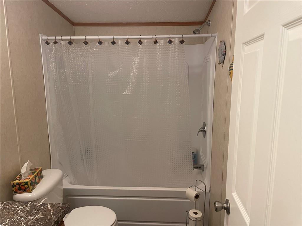 14624 Gilliland Road Linesville, PA 16424 - Photo 21 of 23 a bathroom with a shower curtain and a toilet