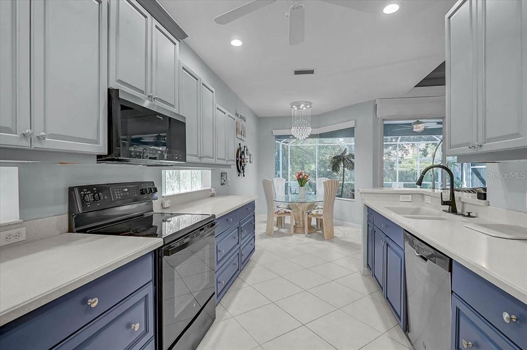 103 Bishopscourt Road Osprey, FL 34229 - Photo 13 of 55 a kitchen with stainless steel appliances granite countertop a sink stove microwave and cabinets