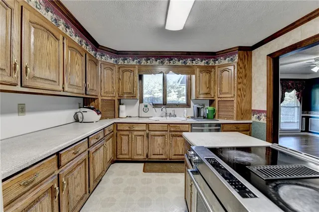 a kitchen with stainless steel appliances granite countertop a sink stove and cabinets