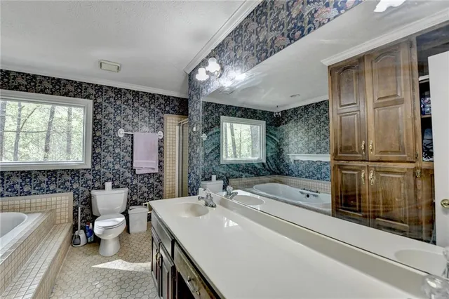 a spacious bathroom with a tub sink and mirror