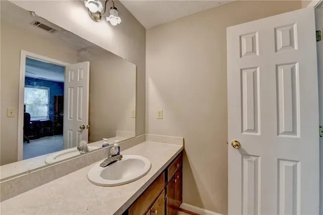 a bathroom with a granite countertop sink and a mirror