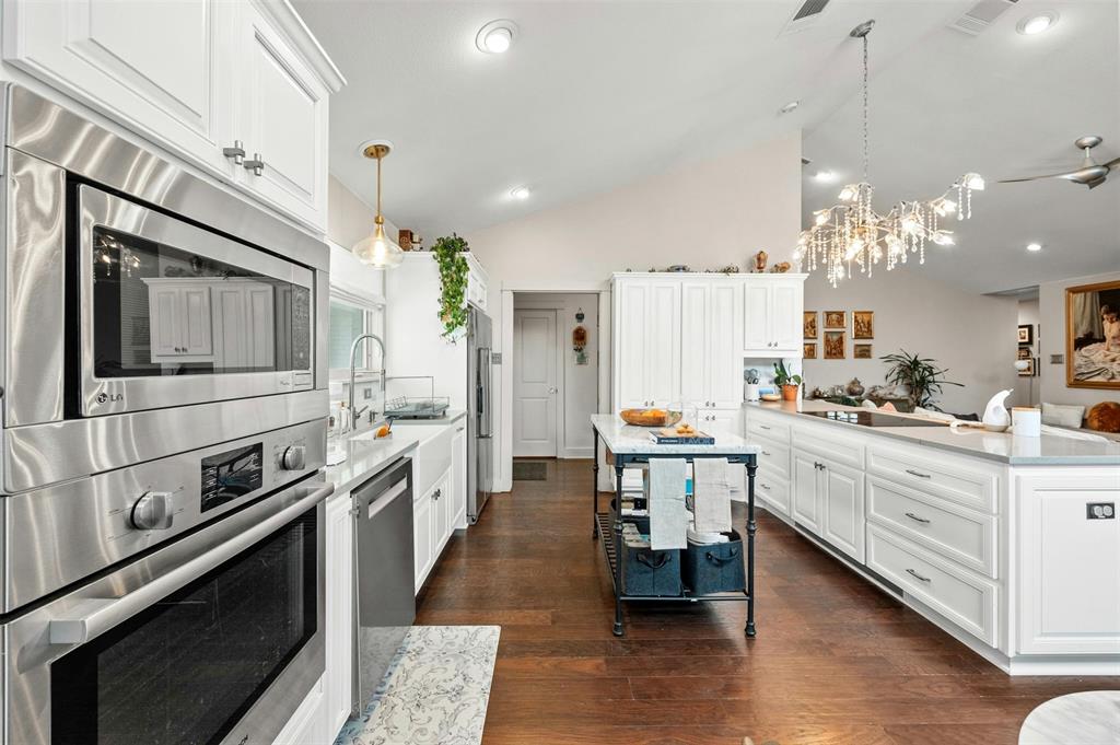 2802 Warren Street, Unit A Austin, TX 78703 - Photo 10 of 29 a kitchen with stainless steel appliances kitchen island granite countertop a stove top oven a sink dishwasher a dining table and chairs with wooden floor