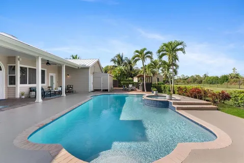 a view of a house with a backyard and bushes