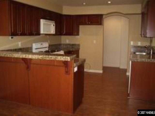 4387 Rancheria Road Fallon, NV 89406 - Photo 5 of 6 a kitchen with stainless steel appliances granite countertop a refrigerator a stove a sink and a refrigerator