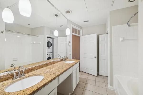a bathroom with a granite countertop sink mirror and a shower