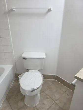 a white toilet sitting next to a bath tub