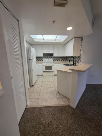 a kitchen with a sink a refrigerator and cabinets