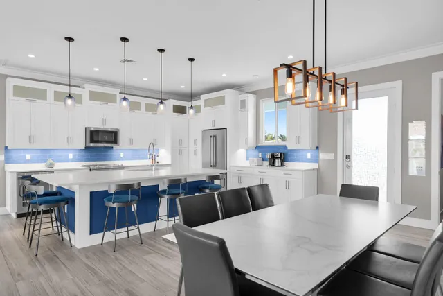 a kitchen with stainless steel appliances a white refrigerator a stove and a sink with granite countertops