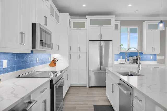 a large kitchen with stainless steel appliances lots of counter space a sink and a wooden floors