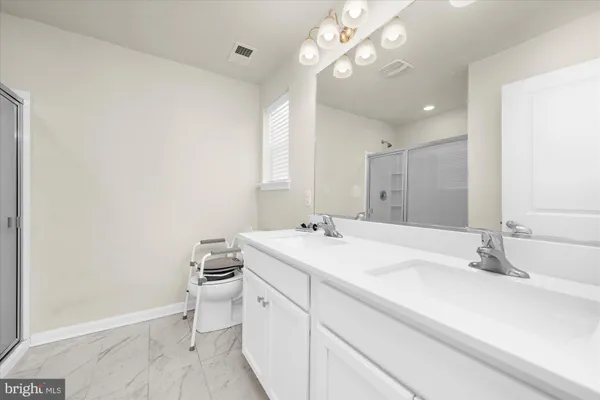 a bathroom with a sink a light fixture and a mirror