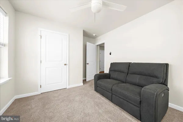 a living room with furniture and a ceiling fan