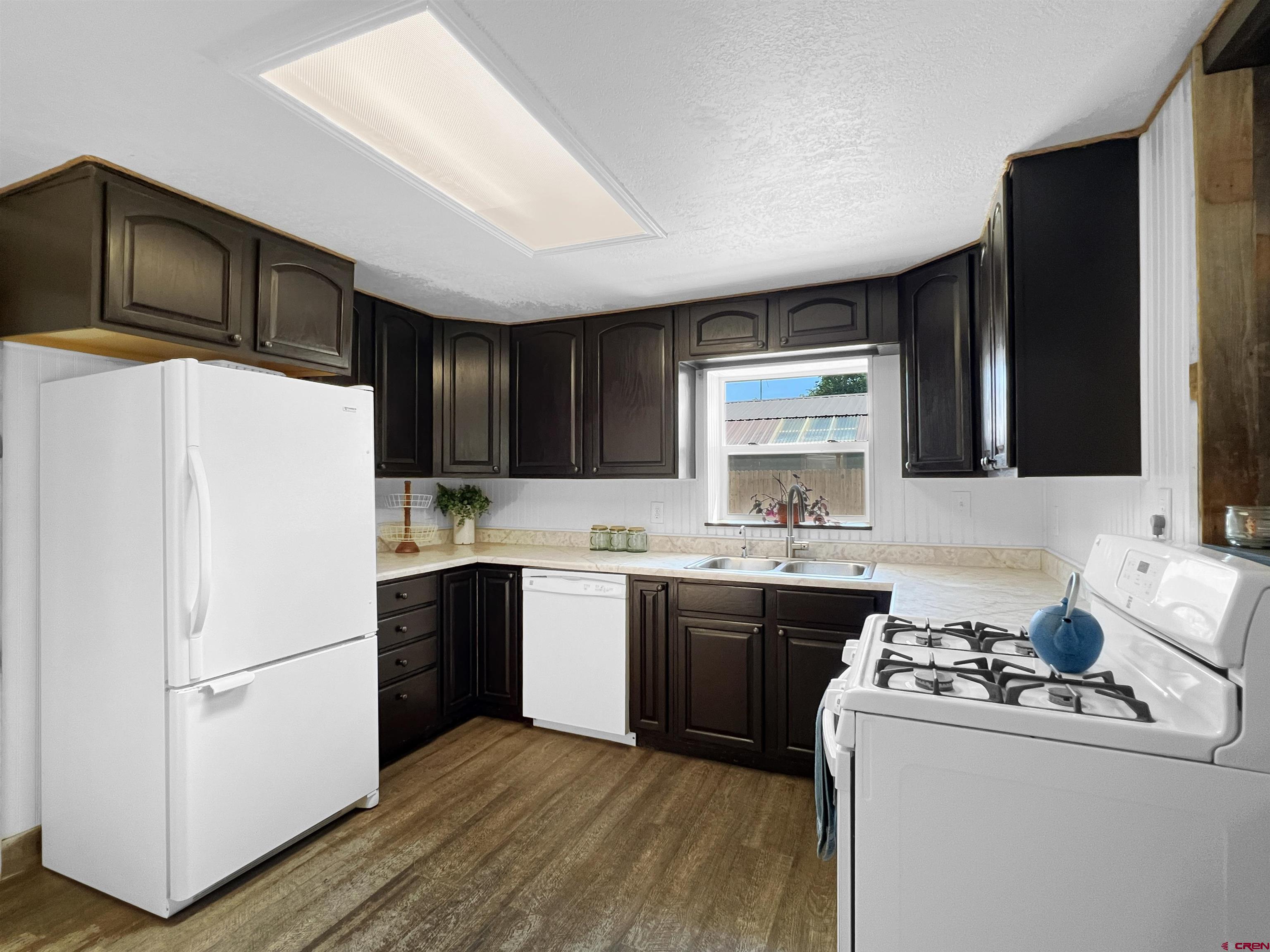 1002 East Carpenter Street Cortez, CO 81321 - Photo 15 of 42 a kitchen with a sink a stove a refrigerator and cabinets