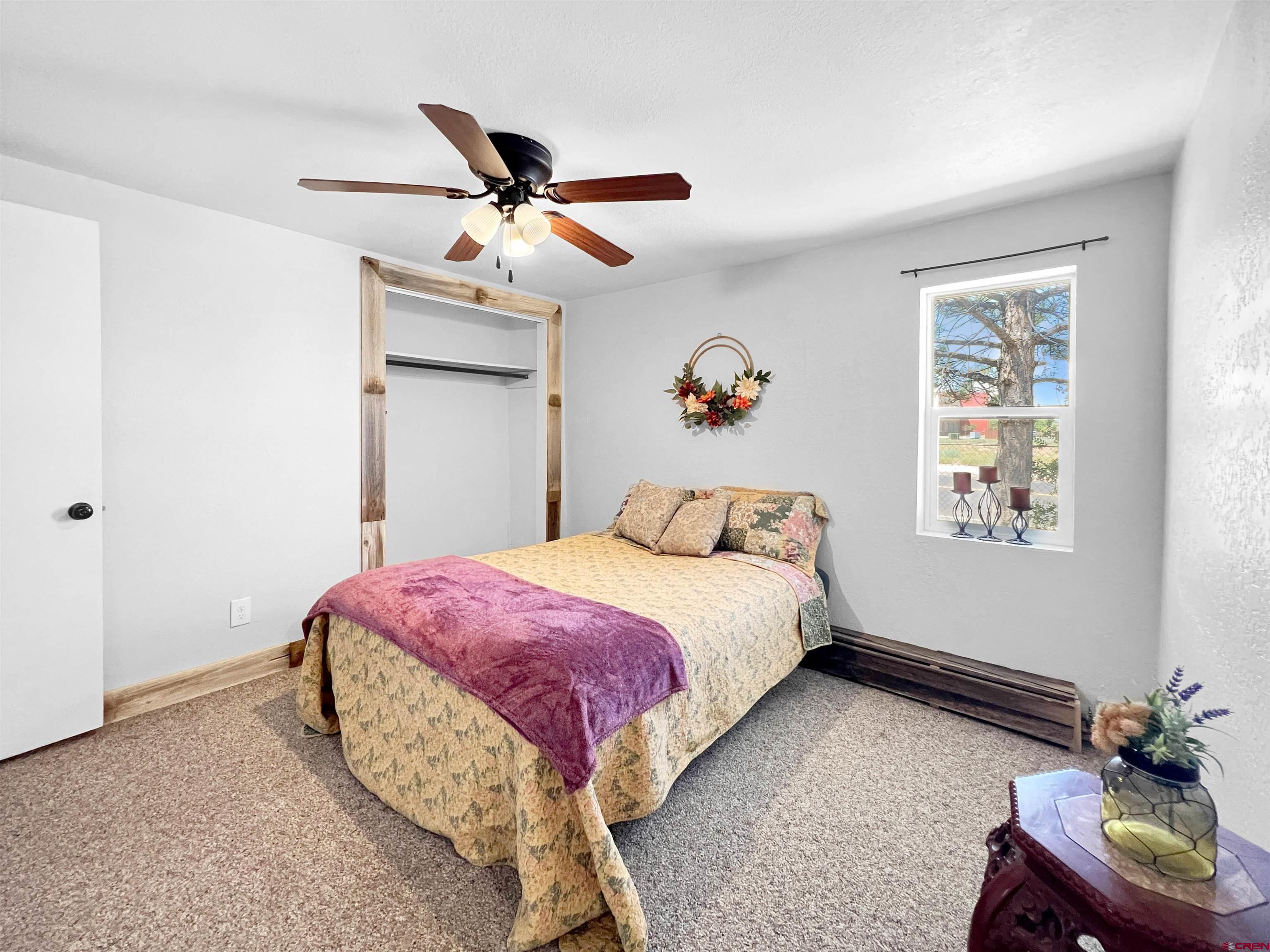 1002 East Carpenter Street Cortez, CO 81321 - Photo 16 of 42 a bedroom with a bed and a chandelier