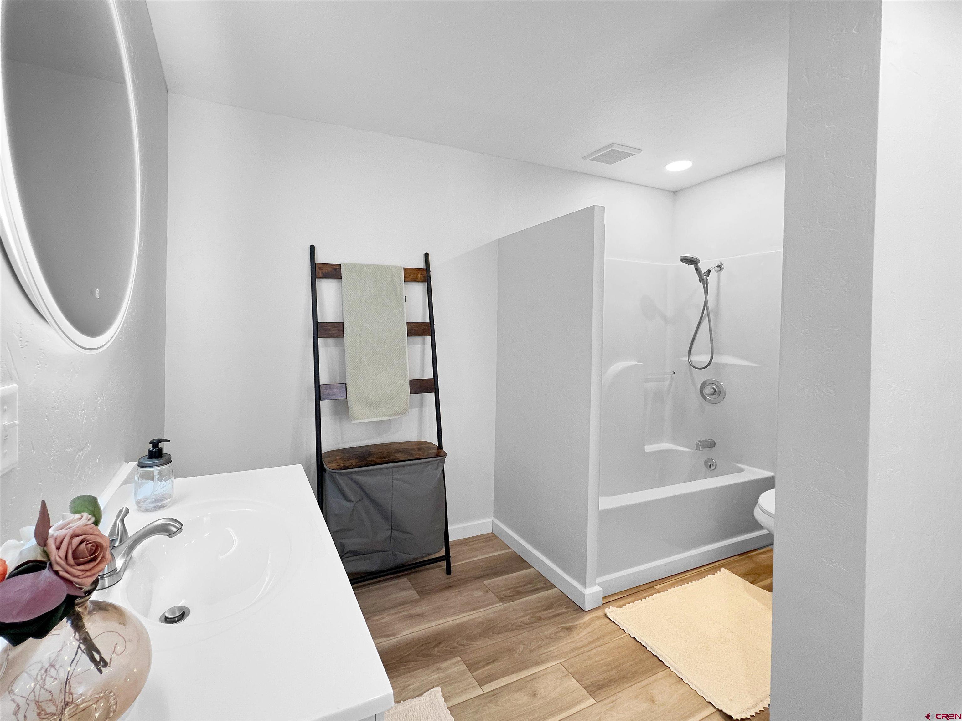 1002 East Carpenter Street Cortez, CO 81321 - Photo 19 of 42 a bathroom with a tub sink and mirror