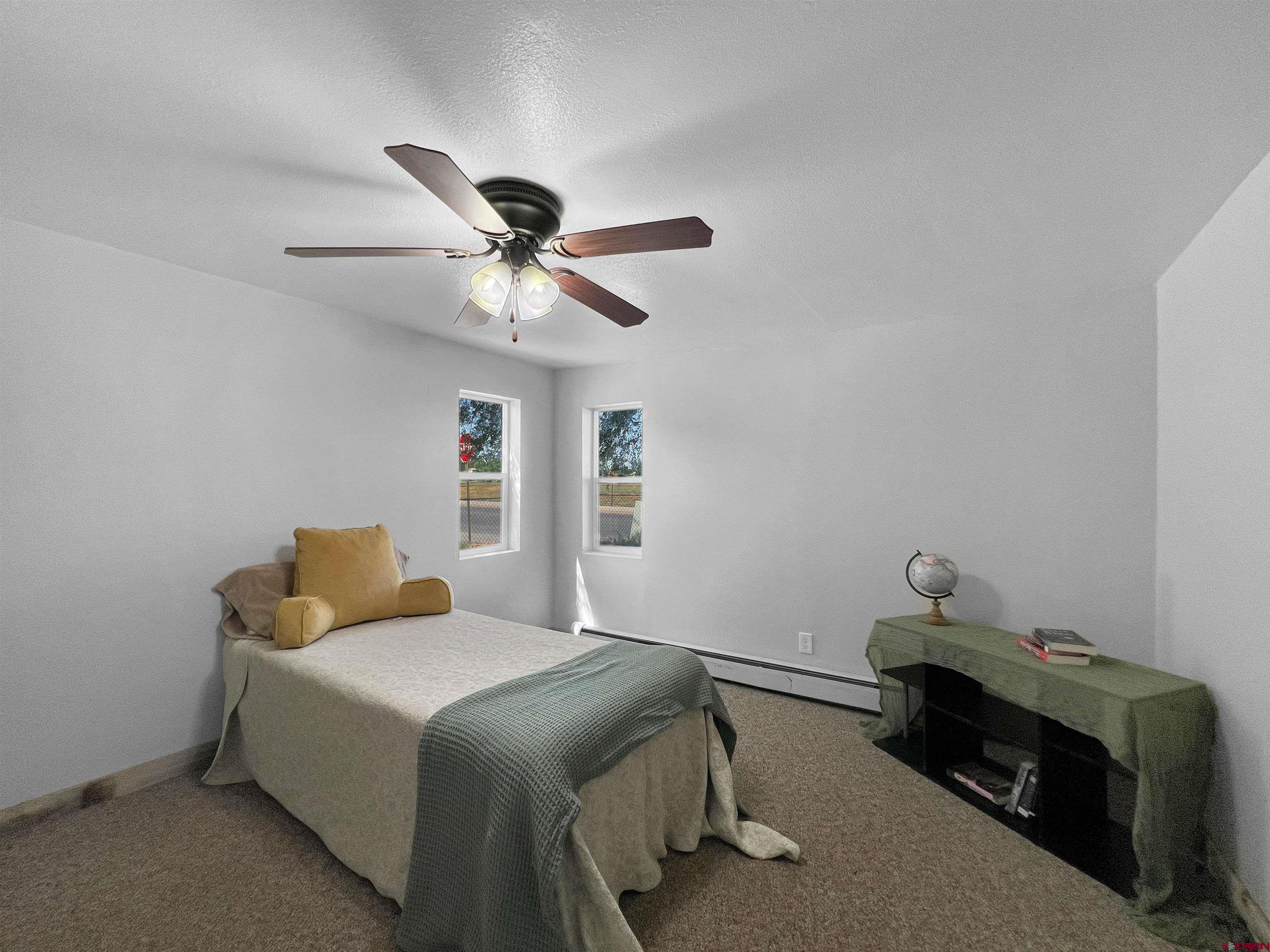 1002 East Carpenter Street Cortez, CO 81321 - Photo 22 of 42 a bedroom with a bed and a chandelier fan