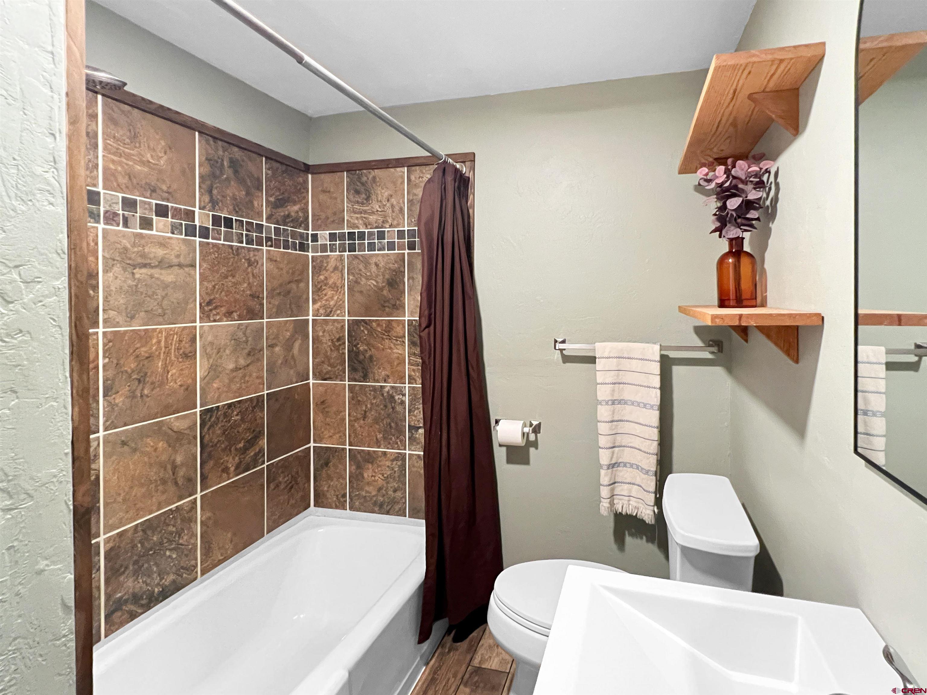 1002 East Carpenter Street Cortez, CO 81321 - Photo 25 of 42 a bathroom with a toilet and a tub