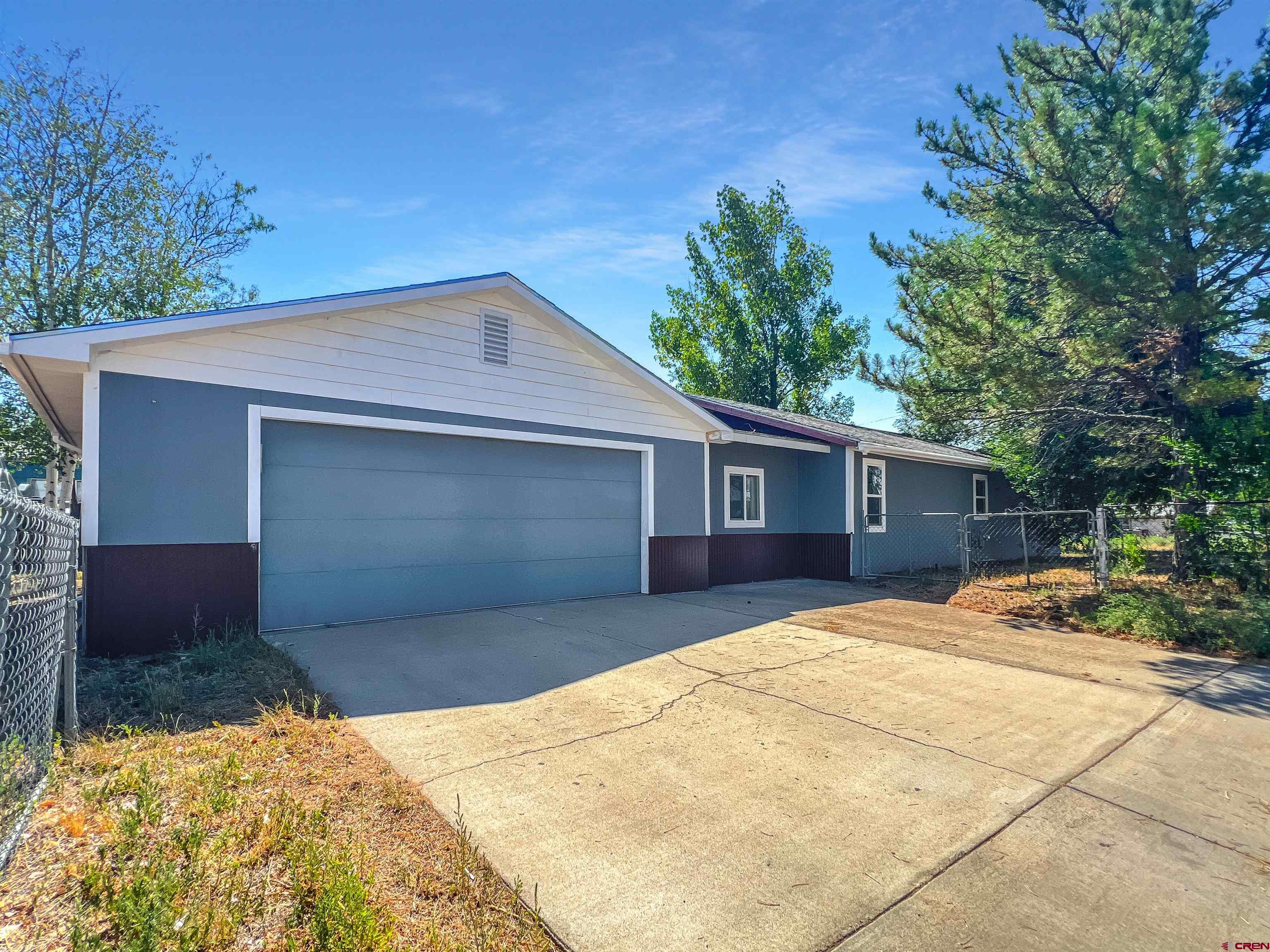 1002 East Carpenter Street Cortez, CO 81321 - Photo 33 of 42 a front view of a house with a yard and garage