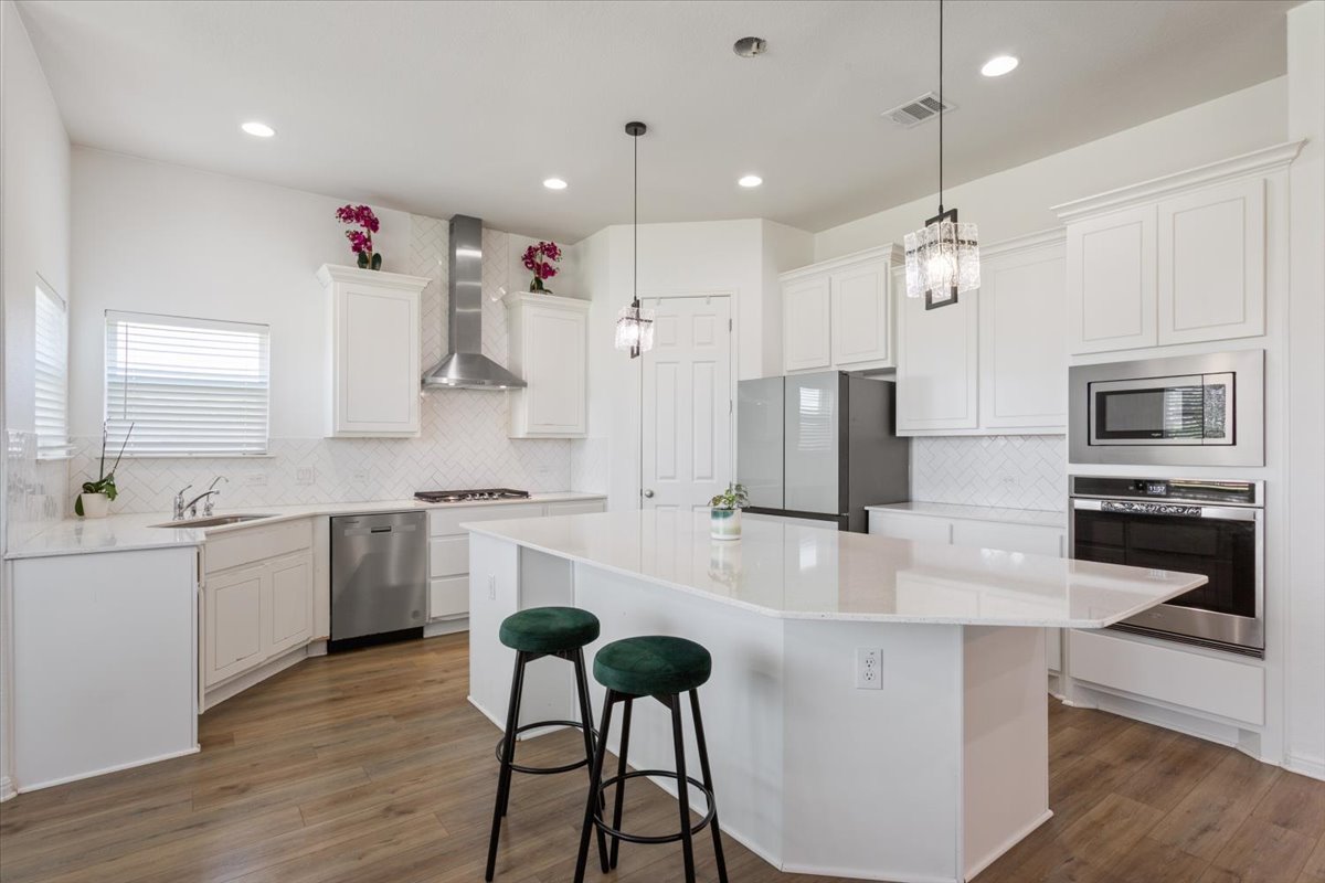 3625 Garrano Bend Leander, TX 78641 - Photo 11 of 38 A well-lit kitchen boasts a generous island with counter seating, perfect for casual dining and entertaining.