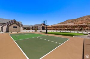 1141 East Lost Ridge Drive Washington, UT 84780 - Photo 22 of 108 Multi-sport court with a basketball hoop, green turf area, and surrounding desert landscaping