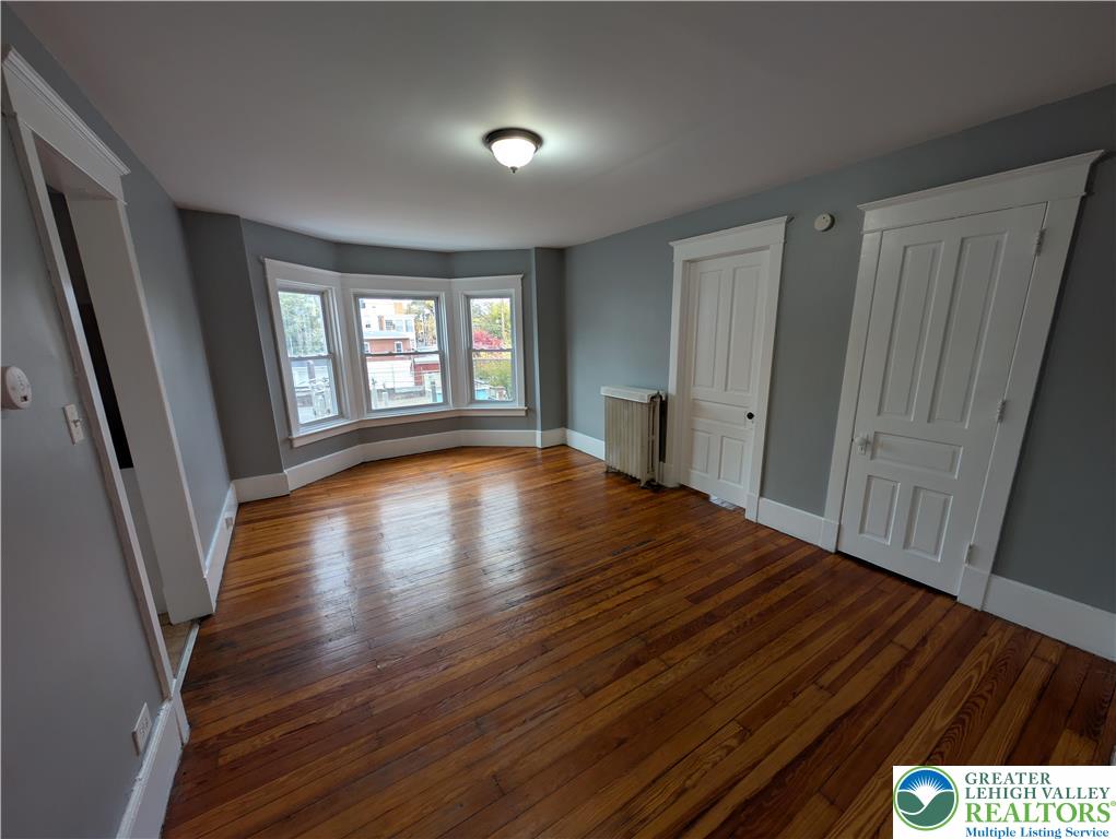 1027 Walnut Street, Unit 3 Allentown, PA 18102 - Photo 2 of 14 a view of an empty room with wooden floor and a window