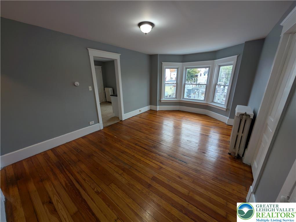 1027 Walnut Street, Unit 3 Allentown, PA 18102 - Photo 3 of 14 a view of empty room with wooden floor and fan