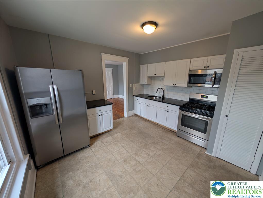 1027 Walnut Street, Unit 3 Allentown, PA 18102 - Photo 4 of 14 a kitchen with stainless steel appliances a refrigerator sink and microwave