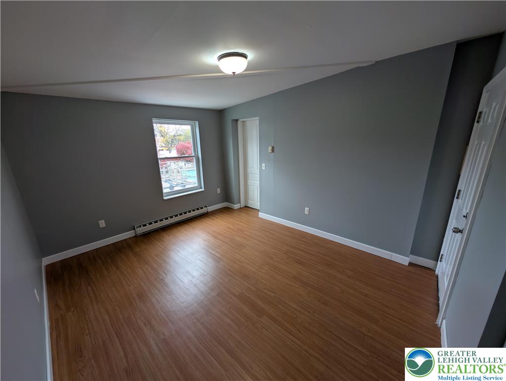 1027 Walnut Street, Unit 3 Allentown, PA 18102 - Photo 8 of 14 an empty room with wooden floor and windows