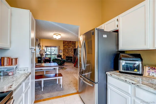 a kitchen with stainless steel appliances kitchen island granite countertop a refrigerator and a stove top oven