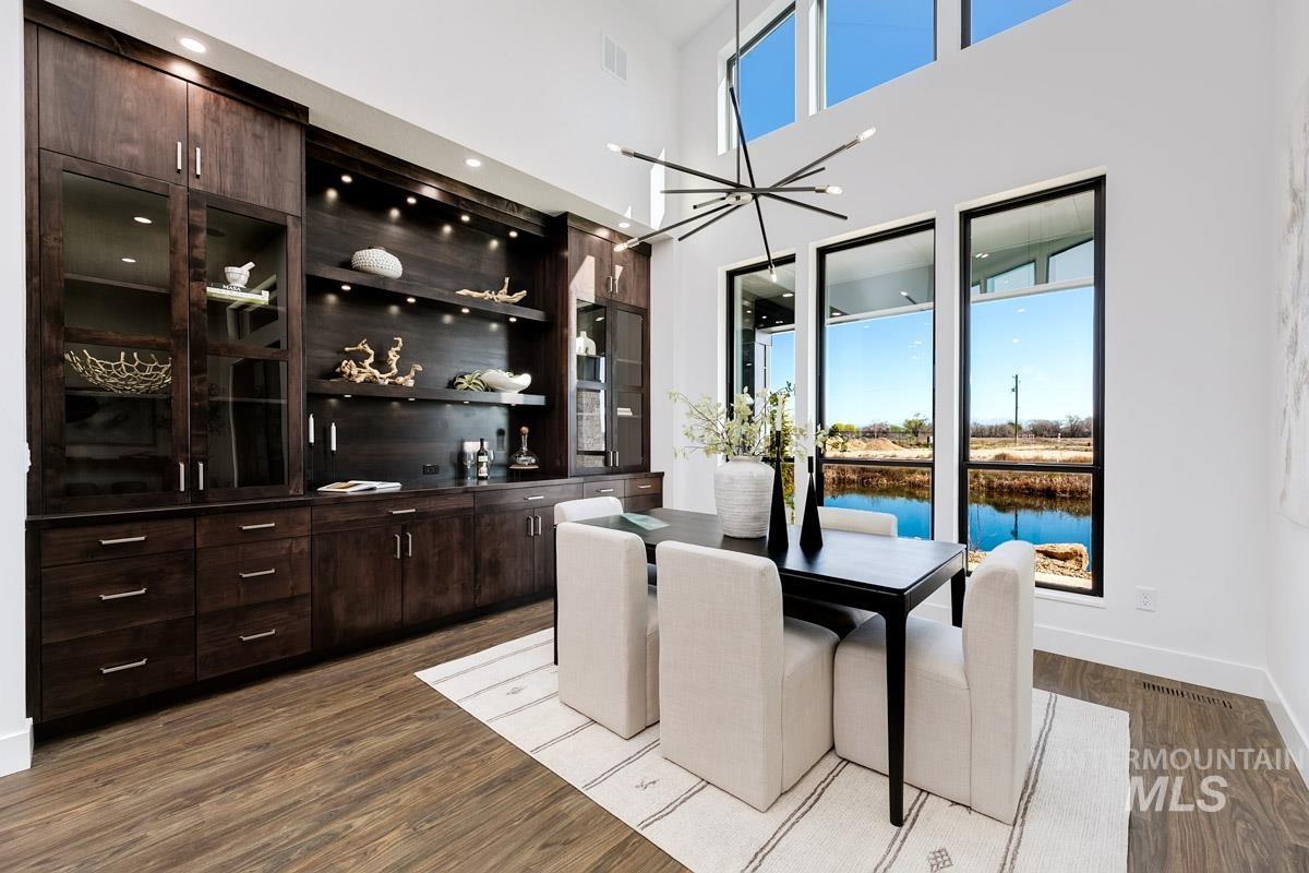 525 Founder Avenue Middleton, ID 83644 - Photo 14 of 50 Dining room featuring a high ceiling, dark wood-style floors, a water view, and hanging lights