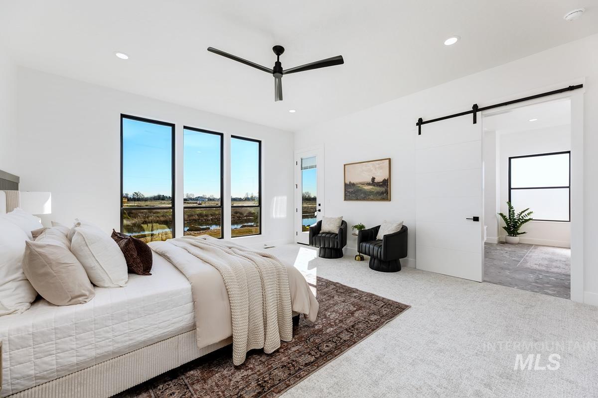 525 Founder Avenue Middleton, ID 83644 - Photo 22 of 50 Carpeted bedroom featuring a barn door, access to outside, ceiling fan, a water view, and recessed lighting