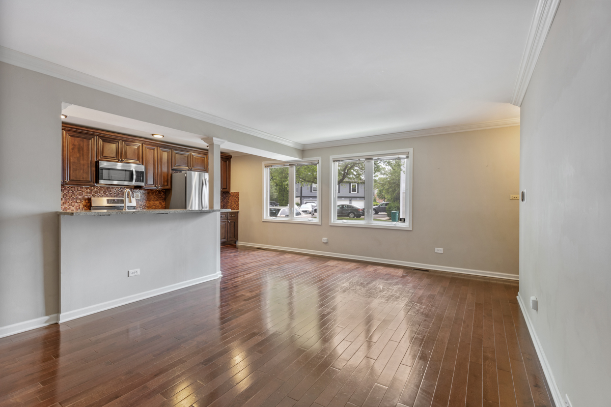 1004 Inverrary Lane Deerfield, IL 60015 - Photo 3 of 19 a view of a kitchen and an empty room with wooden floor and a window
