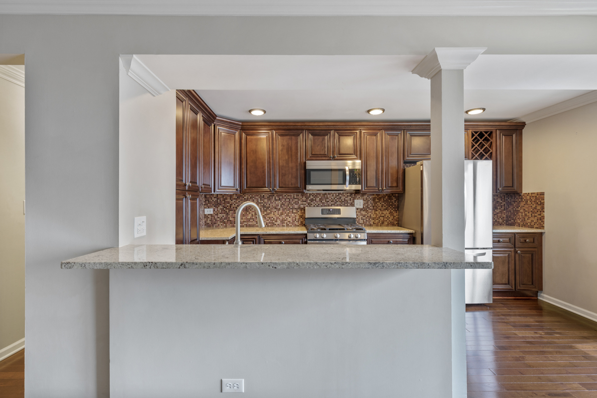 1004 Inverrary Lane Deerfield, IL 60015 - Photo 6 of 19 a kitchen with stainless steel appliances granite countertop a sink refrigerator and cabinets
