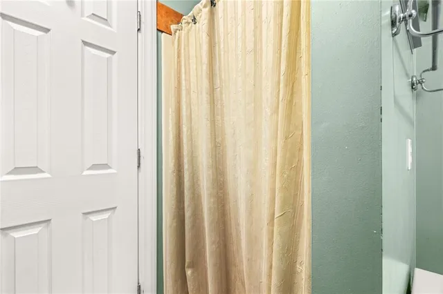 a backyard of a house with a large tree and wooden fence