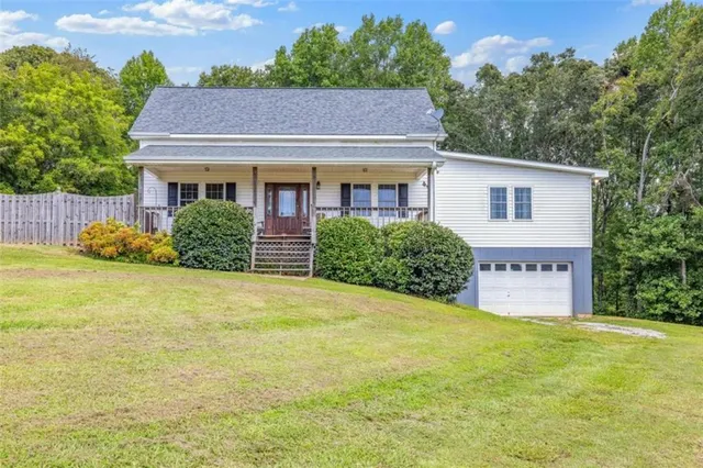 a view of a house with a yard and a large tree